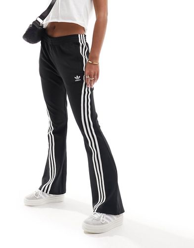 Pantaloni sportivi a zampa con tre strisce neri - adidas Originals - Modalova