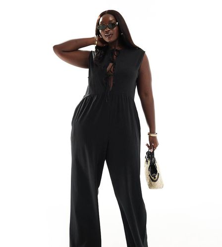 ASOS DESIGN Curve - Tuta jumpsuit nera a fondo ampio allacciata sul davanti - ASOS Curve - Modalova