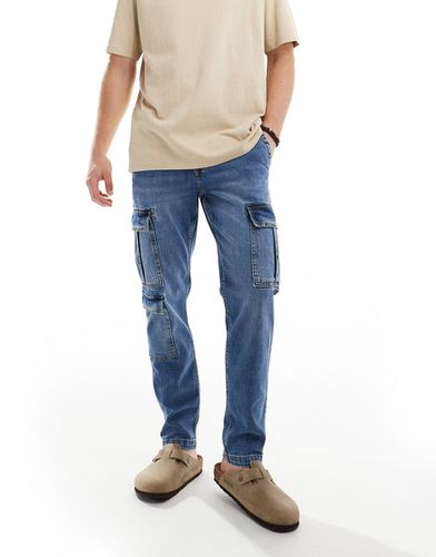 Jeans affusolati elasticizzati lavaggio medio con tasche cargo - ASOS DESIGN - Modalova