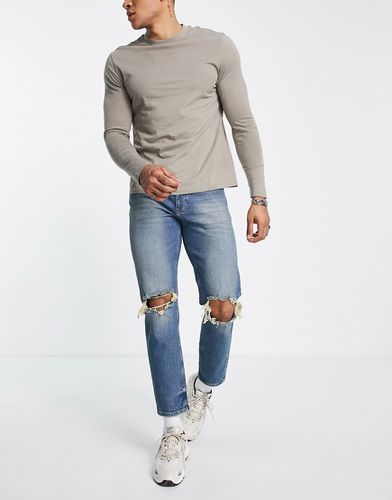 Jeans affusolati lavaggio scuro con strappi vistosi sulle ginocchia - ASOS DESIGN - Modalova