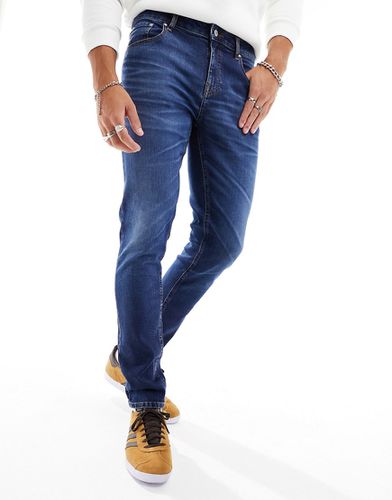 Jeans skinny scuro slavato - ASOS DESIGN - Modalova