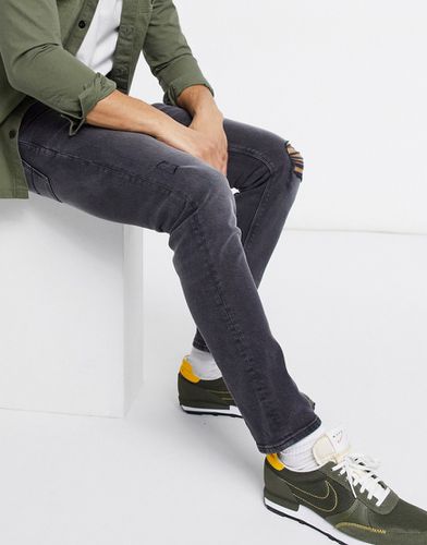 Jeans slim elasticizzati slavato con strappi sulle ginocchia e abrasioni - ASOS DESIGN - Modalova