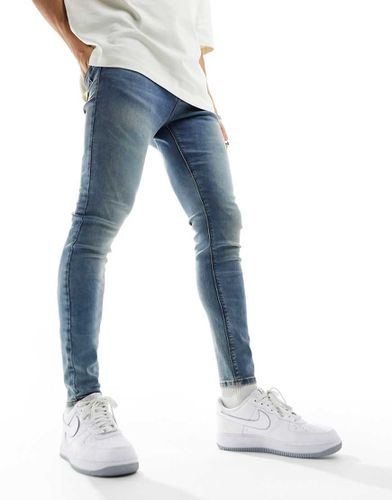 Jeans spray on power stretch lavaggio medio tinto - ASOS DESIGN - Modalova