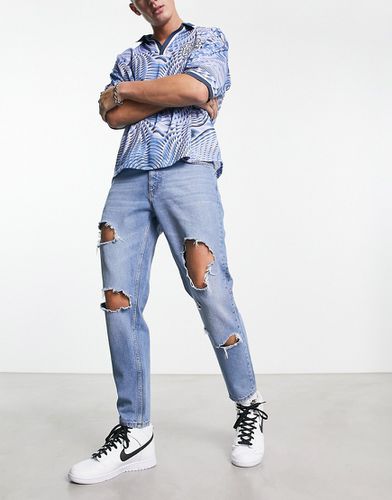 Jeans rigidi classici lavaggio medio con strappi vistosi sulle ginocchia - ASOS DESIGN - Modalova