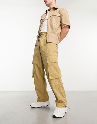 Pantaloni cargo a fondo ampio con vita elasticizzata in nylon beige - ASOS DESIGN - Modalova