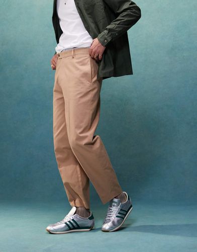 Pantaloni chino eleganti oversize affusolati in cotone color cuoio con pieghe sul davanti - ASOS DESIGN - Modalova