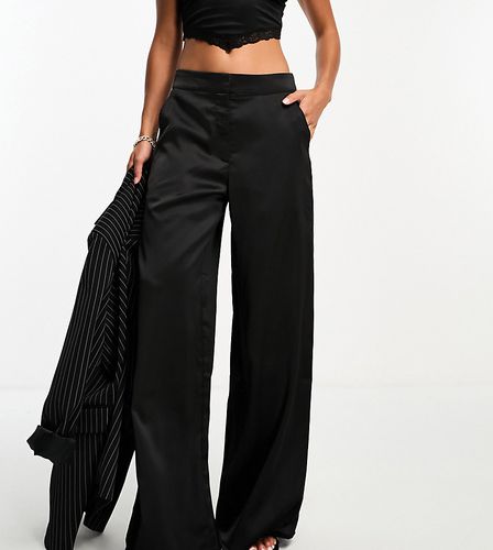 Esclusiva - Pantaloni con fondo ampio in raso neri - In The Style Petite - Modalova