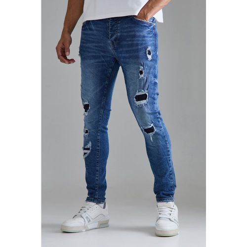 Jeans Skinny Fit Stretch strappati di colore blu medio - boohoo - Modalova