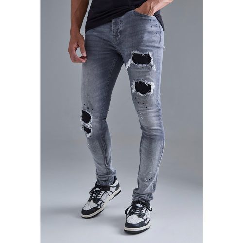 Jeans Super Skinny Fit elasticizzati medio con strappi & rattoppi e pieghe sul fondo - boohoo - Modalova