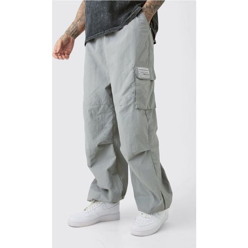 Pantaloni da paracadutista Tall con pieghe sul ginocchio e logo - boohoo - Modalova