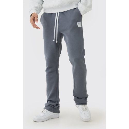 Pantaloni tuta a zampa Slim Fit con etichetta intessuta e inserti - boohoo - Modalova