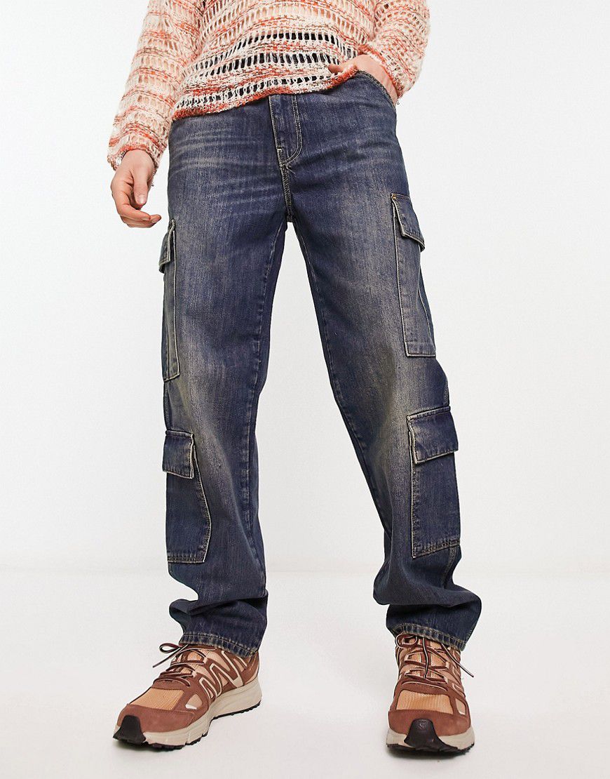 Jeans a fondo ampio tinta scura con tasche cargo - ASOS DESIGN - Modalova