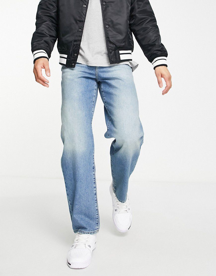 Jeans larghi lavaggio medio - ASOS DESIGN - Modalova